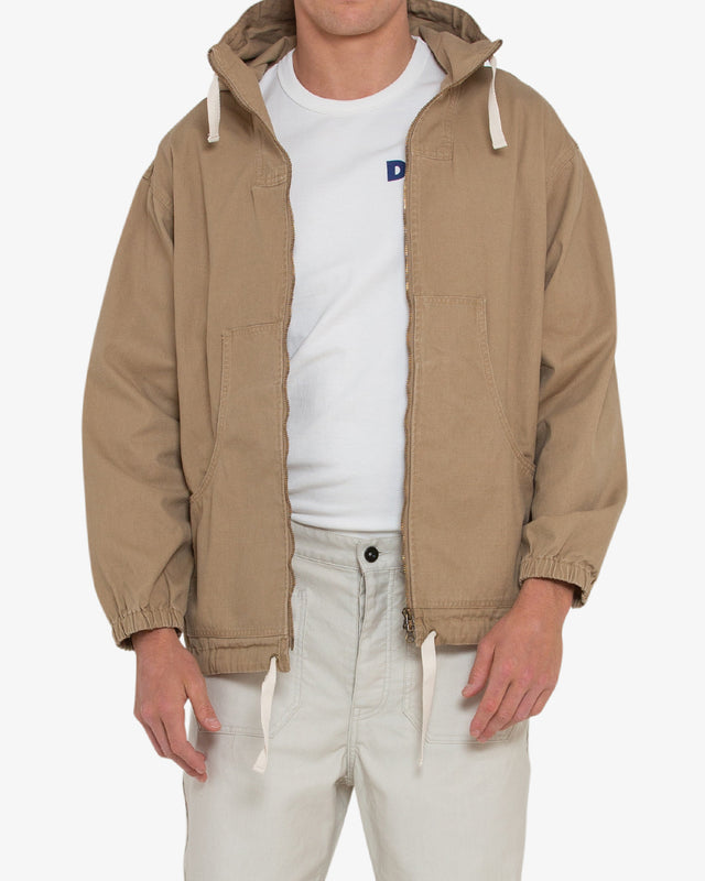 tan relaxed fit parka with elasticated cuffs and adjustable drawstring hem, large front pockets, two way zip opening, wind and rain resistant in a 100% cotton canvas fabrication with dry wax finish